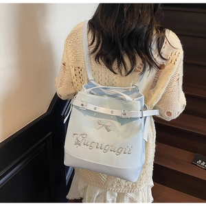 Détail du sac à dos en cuir synthétique bleu clair avec broderie nœud argenté