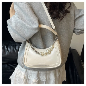 Détail du sac demi-lune en cuir PU blanc avec poignée en perles et billes argentées