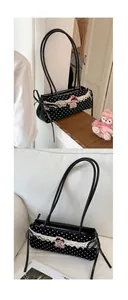 Détail du sac sous le bras à pois noirs avec dentelle blanche et petit nœud rouge