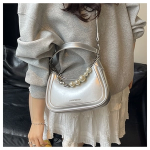 Détail du sac argenté métallisé avec poignée en perles et logo Luckymia embossé