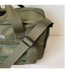 Close-up of the smooth adjustable shoulder strap and hardware on the green travel bag