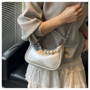 Detail of silver metallic hobo bag featuring pearl chain and mirror leather texture