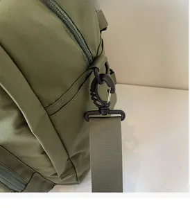 Detailed macro view of the heavy-duty black swivel hook and green nylon webbing strap