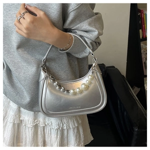 Détail du sac demi-lune argenté métallisé avec perles décoratives et chaîne fine