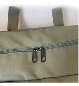 Detail of smooth metal double zippers on army green canvas travel bag with dual pullers