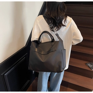 Grand sac fourre-tout noir en nylon avec bandoulière réglable en situation réelle