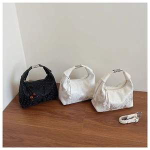 Detail of boutique handbags featuring butterfly prints and metallic beaded drawstrings