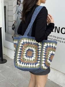 Bohemian crochet tote bag with colorful geometric patterns worn by a model in the city