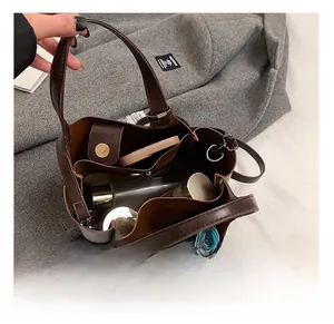 Macro shot of dark brown tote bag interior with multiple functional compartments and magnetic closure