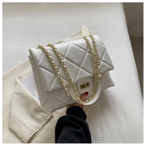 Close-up of a white quilted crossbody bag with golden chain strap and twist lock detail