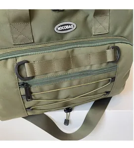 Close-up of army green travel bag featuring tactical Molle webbing and D-ring attachment
