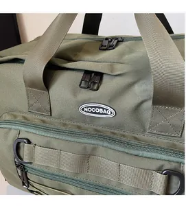 Close-up of army green travel bag showing reinforced nylon straps and metal zippers