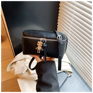 Detail of black leather mini box bag featuring a unique silver robot zipper charm