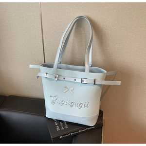 Détail du grand sac cabas bleu clair avec nœud papillon et broderie sur cuir souple