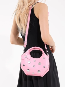 Sac seau rose en cuir verni avec clous argentés et nœud, porté en perspective arrière