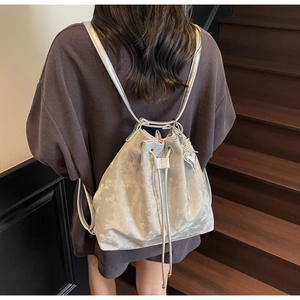 Silver drawstring bucket backpack with marble texture and metallic strap shown on model