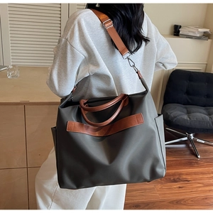 Détails de dos d'un grand sac cabas vert olive avec anses en cuir marron et poches latérales
