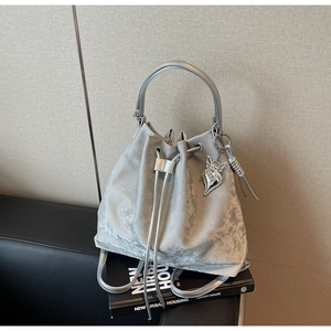 Close-up of silver bucket bag with pleated metallic texture and heart butterfly charm