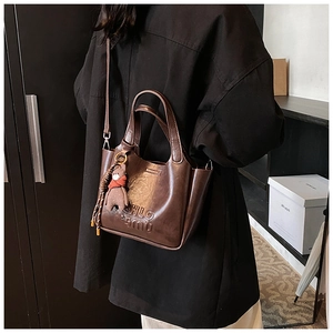 Detail of vintage brown shoulder bag with CHLO mu embossed logo and bear charm