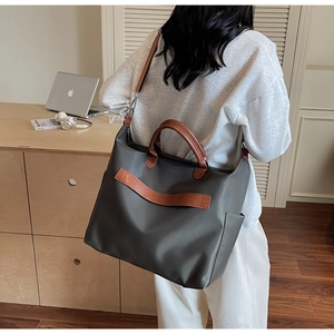 Grand sac cabas en nylon gris avec poignées en cuir marron et poches latérales