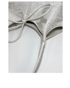 Detailed macro view of a silver bucket bag with glitter texture and a bow knot ornament
