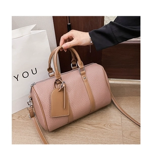 Detail of rose pink litchi grain leather boston bag with detachable shoulder strap