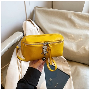 Detail of yellow lychee textured mini crossbody bag with a robot-shaped metal zipper