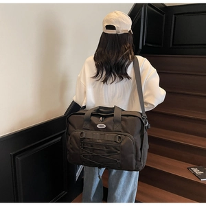 Large black travel bag detail showing HOCOBAG logo and reinforced straps on stairs