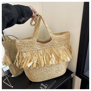 Detail of hand-woven straw tote bag with fringe accents for summer beach vacation