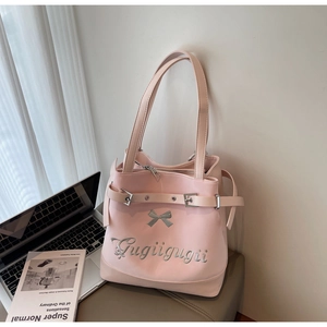 Gros plan du sac cabas rose à nœud avec broderie argentée et détails de boucle en métal