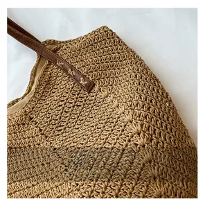 Détail de la texture en paille tressée et bandoulière en cuir avec coutures