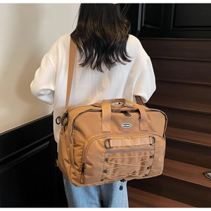 Close-up of a large khaki travel backpack with adjustable straps worn by a model