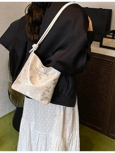 Chic beige shoulder bag with gray butterfly prints and a pearl bow accent for women