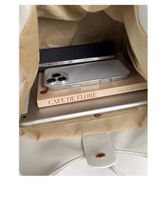 Interior view showing the large capacity of the white tote bag with various daily items
