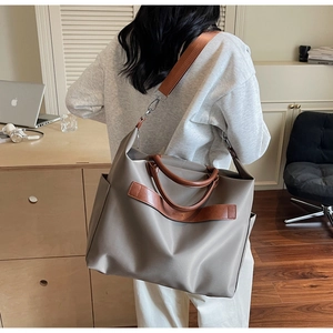 Grand sac fourre-tout en nylon kaki avec anses en cuir marron dans un décor de bureau