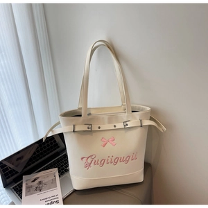 Détail du sac cabas blanc cassé avec broderie nœud rose et boucle métallique