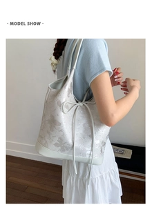 Model show of cream white tote bag with light gray butterfly pattern and bow detail