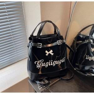 Détail du sac fourre-tout noir brillant avec nœud blanc et broderie artistique fine