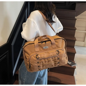 Large brown canvas travel bag with Nocobag logo and adjustable straps on a person