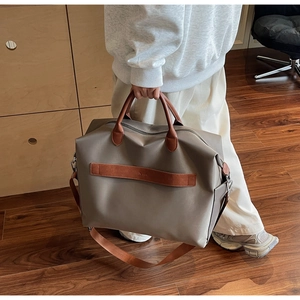 Détail du sac cabas kaki avec poignées en cuir marron et bandoulière réglable