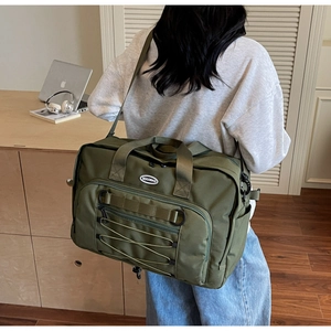 Macro view of army green nylon travel bag showing tactical webbing and drawstrings