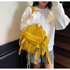 Dettaglio di uno zaino in nylon giallo brillante con fibbie e chiusure a coulisse