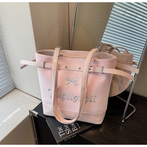 Détail d'un grand sac cabas rose avec nœud argenté et broderie dans un décor chic