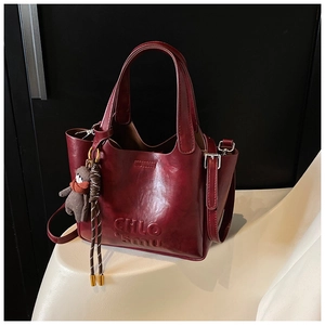 Detailed view of burgundy vintage leather tote with bear charm and CHLO logo embossed