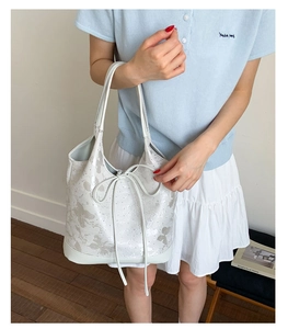 Detail of white printed tote bag with floral bow patterns and double thin shoulder straps