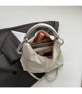 Détail de l'intérieur du grand sac fourre-tout beige montrant un vaste espace de rangement