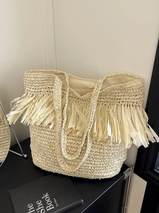 Handwoven cream tote bag with stylish fringe tassels and large capacity for beach vacations