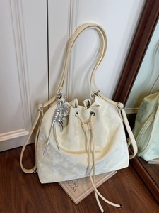 Cream bucket bag in luxury textured leather with drawstring and metallic star charms