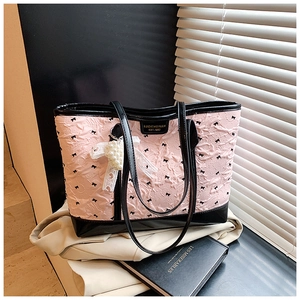 Detail of pink embossed tote bag with black bow embroidery and pearl lace charm