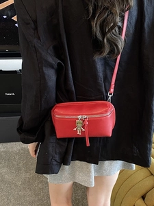 Mini red rectangle crossbody bag with silver zipper and unique robot charm on model